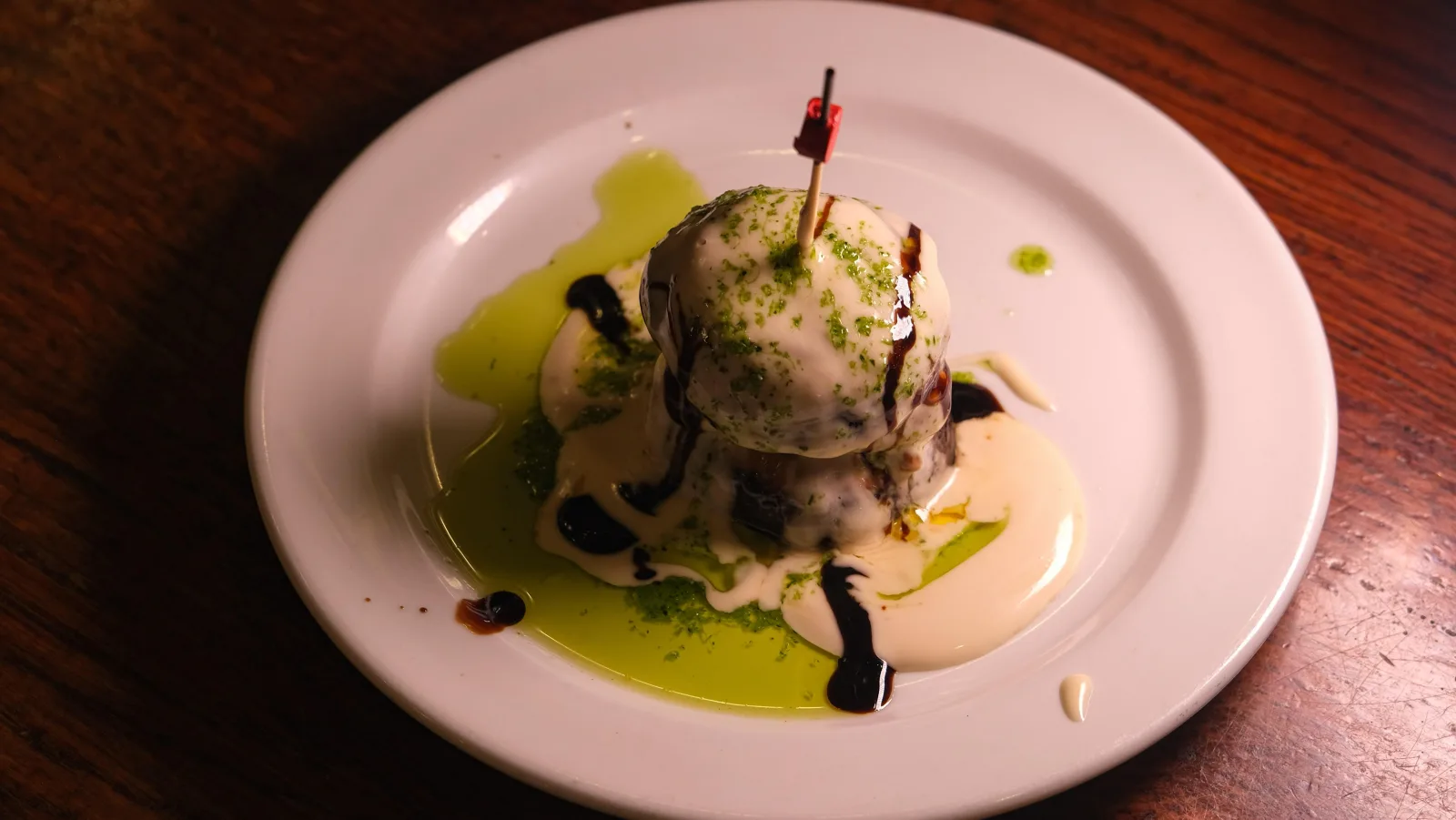 Pintxo of potato salad with olive oil and balsamic on a pale plate