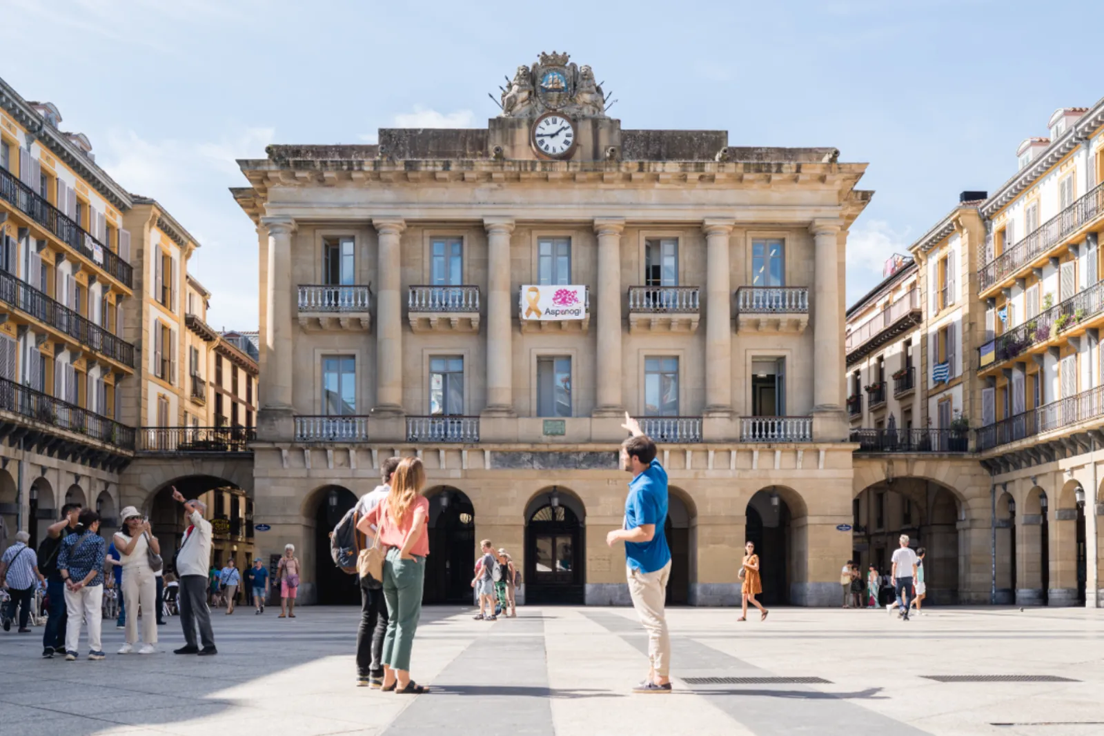Guide talking to visitors on Plaza de la Constitucion in front of the old town hall