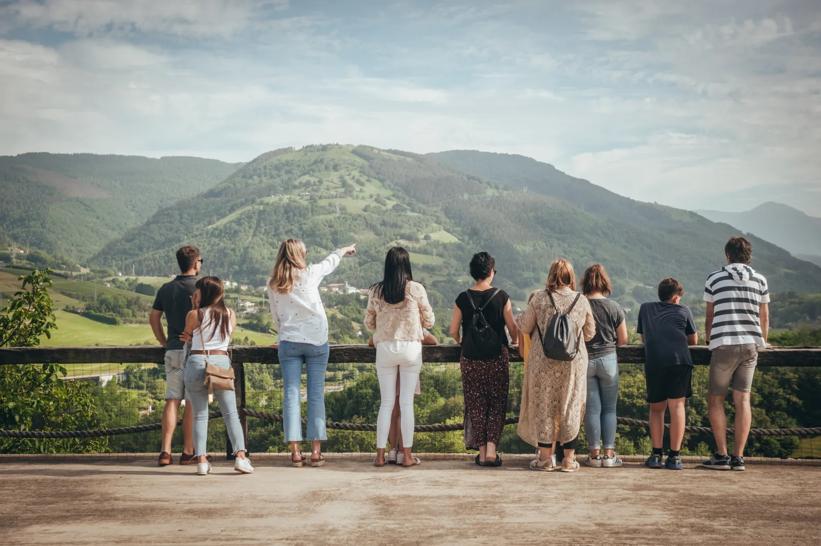 Group at a viewpoint railing looking across the green Gipuzkoa hills