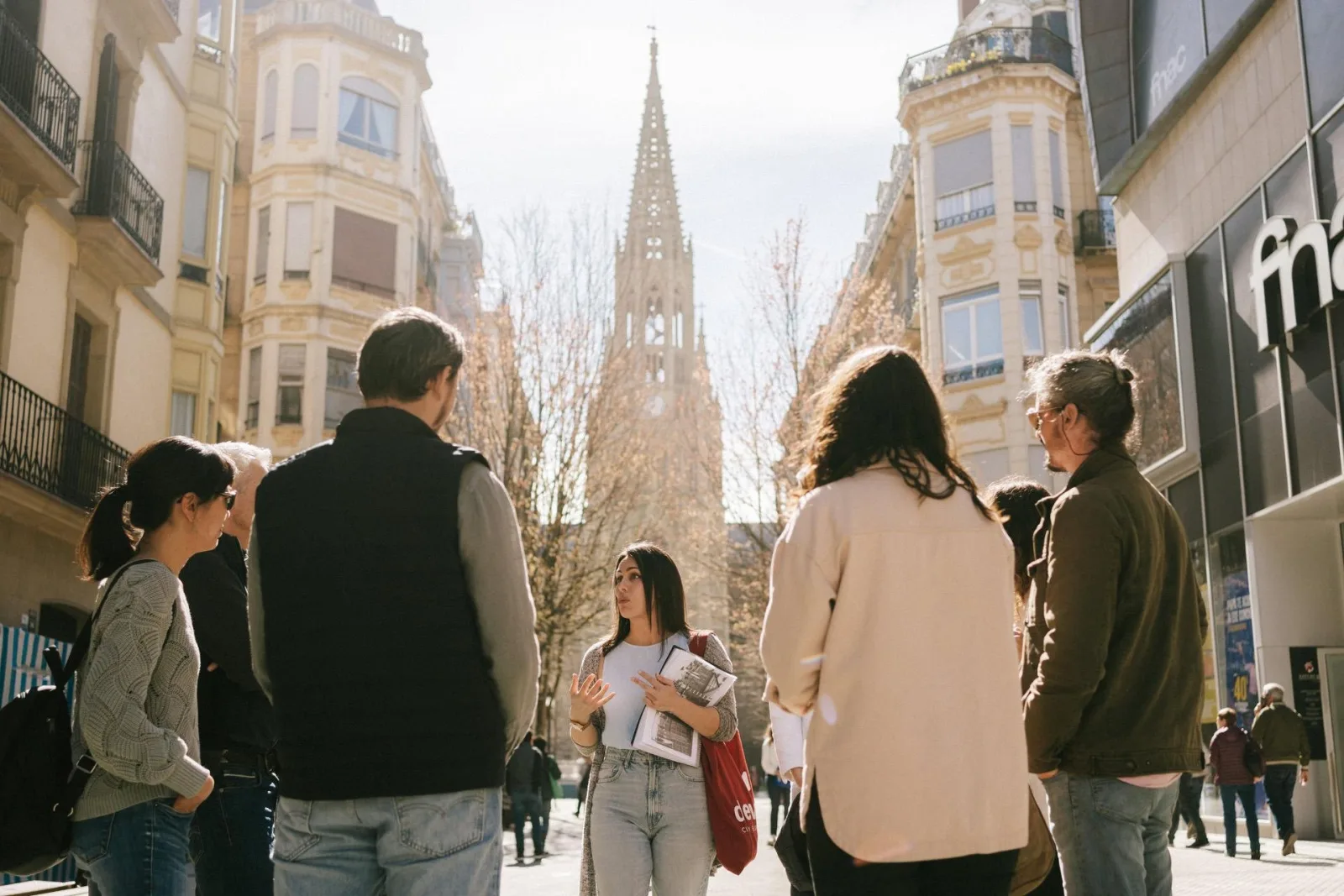 Evening tour group listening to their guide on a street below the cathedral spire
